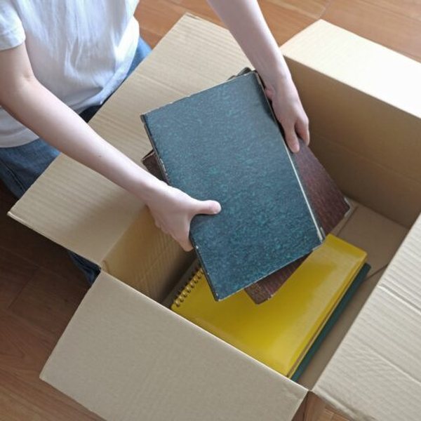 段ボール箱に本を詰めて片付けている様子